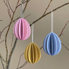 Three wooden Easter eggs by Lovi, size 7cm, colors light pink, honey yellow and flax blue